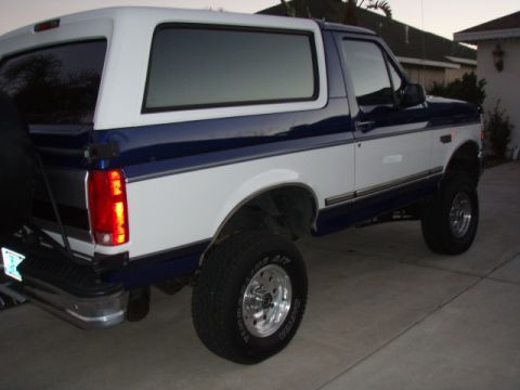 1996 Ford Bronco - This lifted Ford Bronco is shown from the rear three-quarter view, parked on a paved surface.