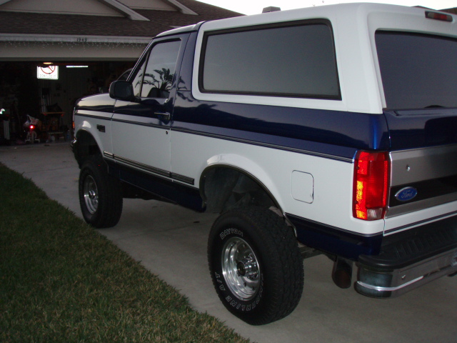 White and blue lifted Ford Bronco parked on a driveway