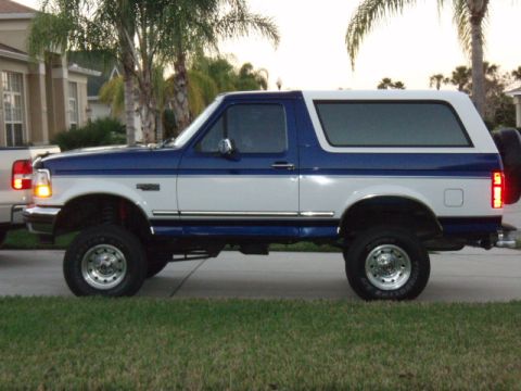 1996 Ford Bronco - This lifted 1996 Ford Bronco features a two-tone blue and white paint scheme and a spare tire mounted on the rear.