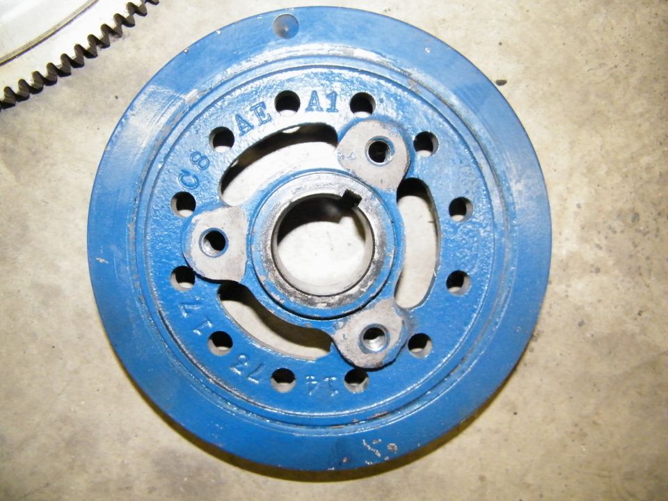 Blue-painted Ford harmonic balancer with C8AE-A1 casting number on a concrete floor