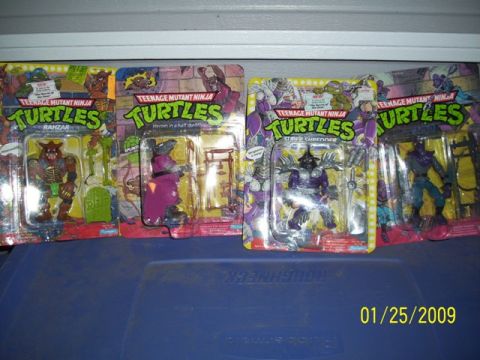 1991 Ford Bronco - A collection of Teenage Mutant Ninja Turtles action figures are displayed on a blue surface.