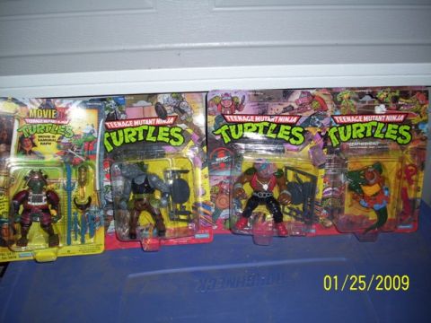 1991 Ford Bronco - A collection of Teenage Mutant Ninja Turtles action figures, including Movie Star Raphael, are displayed in their original packaging.
