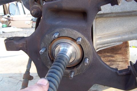 1990 Ford Bronco - Wheel bearing assembly with a ribbed hose inserted, likely during maintenance or repair.