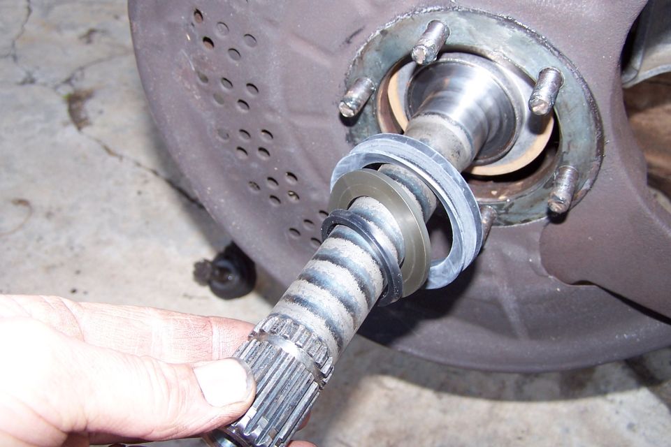 hand holding splined axle shaft with seals and bearing assembly