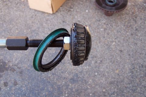 1990 Ford Bronco - A disassembled ball joint component shows wear on the roller bearing and a torn seal.