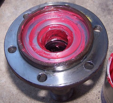 1990 Ford Bronco - A wheel hub assembly is shown packed with bright red grease, ready for installation.