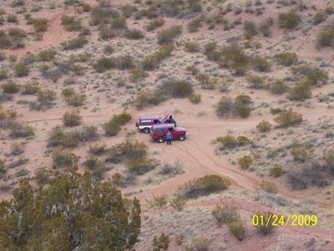 1993 Ford Bronco - Two Ford Broncos are stopped on a dirt track in a dry, arid landscape.