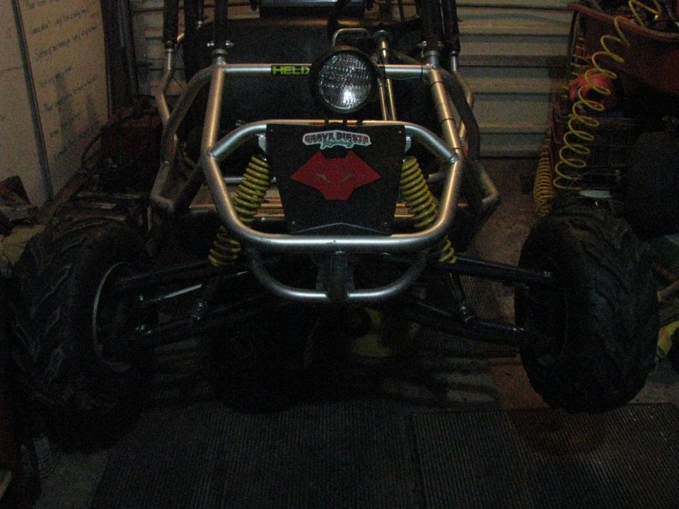 Front view of a go-kart with a roll cage, large tires, and a black plate with a red logo that says 'GRAVE DIGGER'