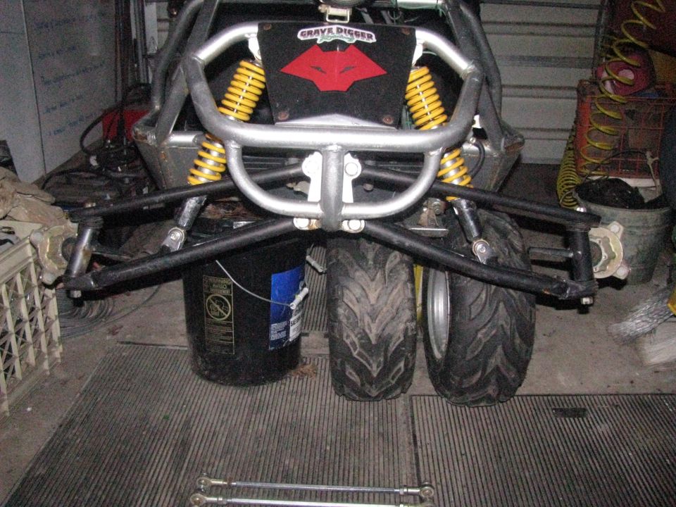 Go-kart rear suspension with yellow shocks and 'Grave Digger' logo