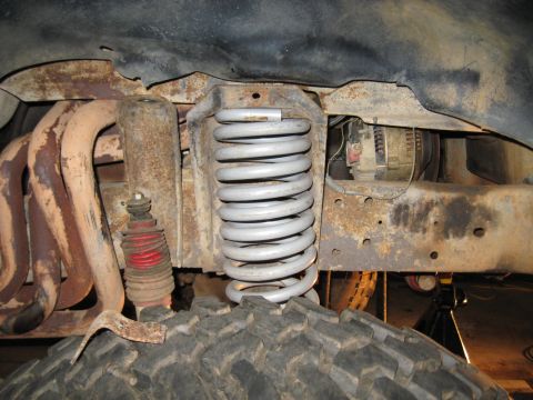 1978 Ford Bronco - Close-up of the heavily rusted suspension components and exhaust system of a 1978 Ford Bronco.
