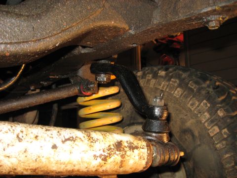 1978 Ford Bronco - Undercarriage view of suspension parts, including a yellow coil spring and steering components.
