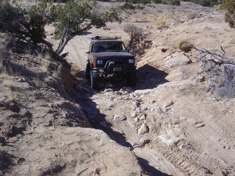 1996 Ford F-250 - Off-road SUV navigating a challenging rocky trail in a desert landscape.