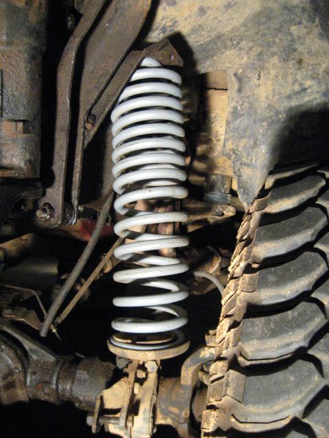 1978 Ford Bronco - The suspension system of a vehicle, a coil spring and a portion of a tire, is shown in detail.