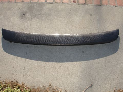 1995 Ford Taurus - A carbon fiber spoiler is shown from a top-down perspective on a concrete surface.