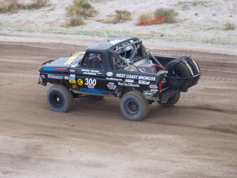 1994 Ford Bronco - This modified truck is seen in a desert environment with racing decals and a roll cage.