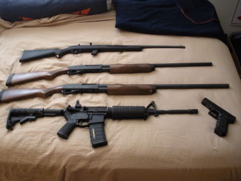 1979 Ford Bronco - A collection of firearms, including rifles and a handgun, are displayed on a bedspread.