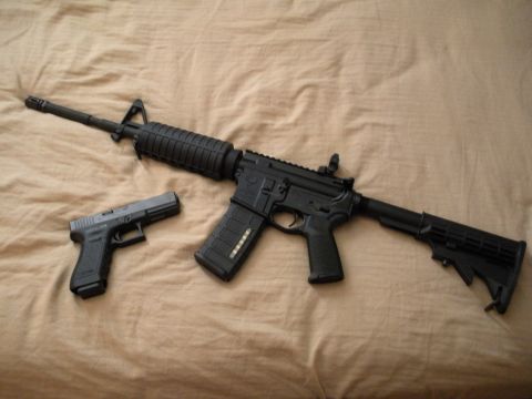 1979 Ford Bronco - An AR-15 style rifle and a Glock handgun are displayed on a textured surface.