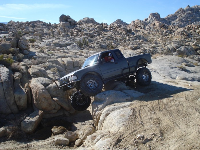 1997 Ford Ranger off-roading over large rocks in a desert landscape