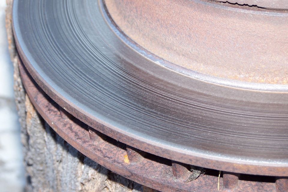 Close-up of a heavily rusted brake rotor with visible wear marks on the surface