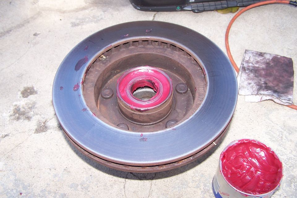 Brake rotor with red grease on the bearing and a can of red grease nearby