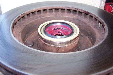 1990 Ford Bronco - A wheel bearing is packed with grease, ready to be installed on a vehicle's brake rotor.