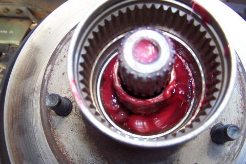 1990 Ford Bronco - Wheel hub assembly packed with red grease, likely for maintenance or repair.
