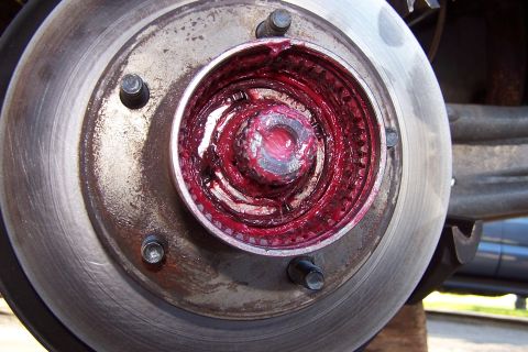 1990 Ford Bronco - Wheel bearing assembly packed with red grease, adjacent to the brake rotor.