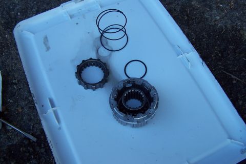 1990 Ford Bronco - Automotive parts, including a gear assembly and O-rings, are laid out on a white plastic tray.