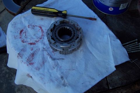 1990 Ford Bronco - A disassembled auto part sits on a stained paper towel next to a screwdriver and some bolts.