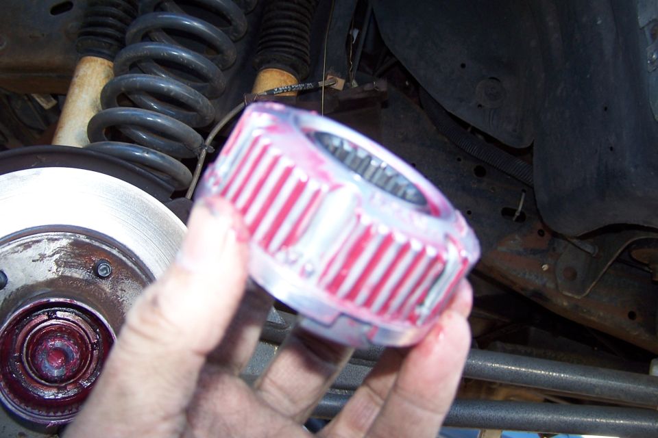 Greased hub assembly part held in hand, with suspension components visible