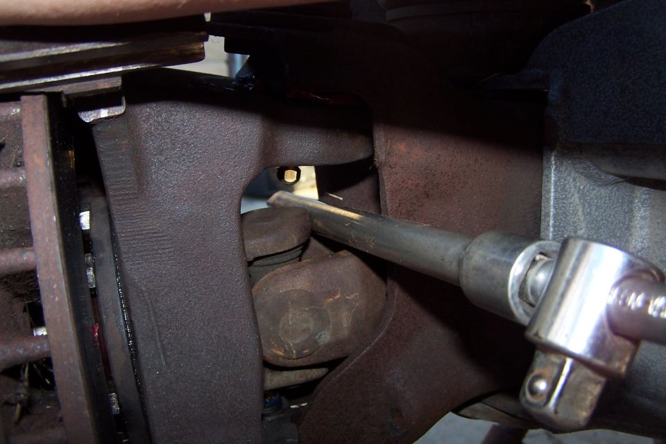 Close-up of rusty suspension components with a socket wrench on a bolt