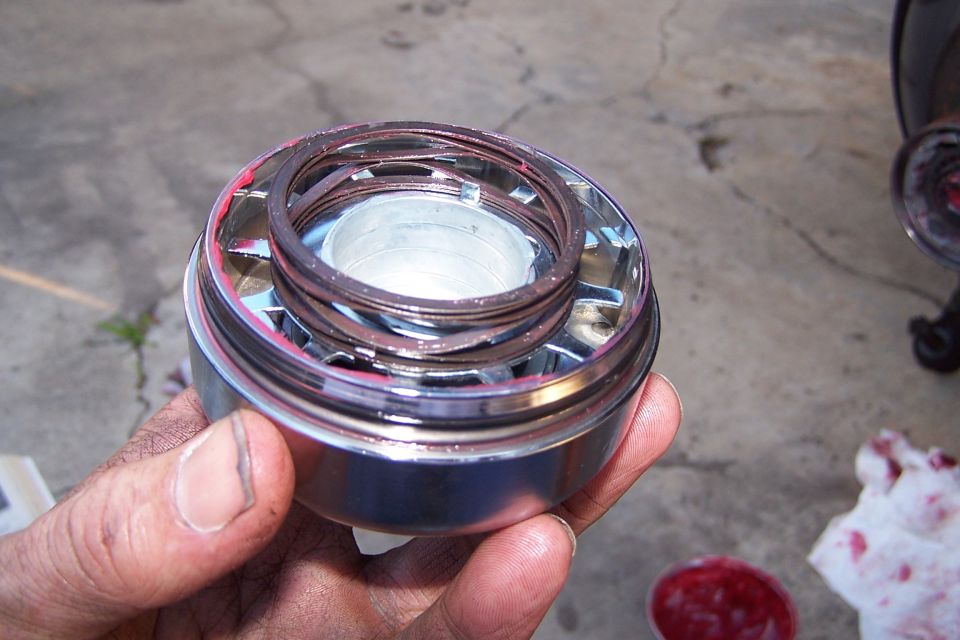 Ball joint assembly with red grease being held by a hand