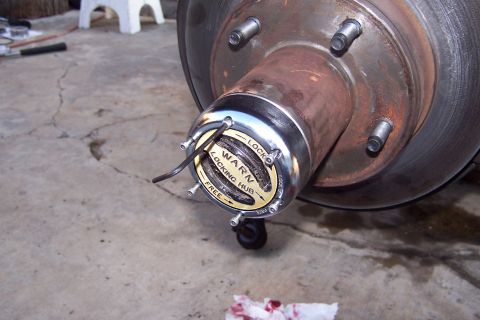 1990 Ford Bronco - A Warn locking hub is shown attached to a vehicle's wheel hub, with a brake rotor visible in the background.