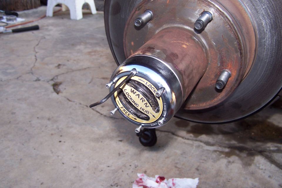 Close-up of a Warn locking hub on a vehicle's wheel hub, showing 'LOCK' and 'FREE' settings