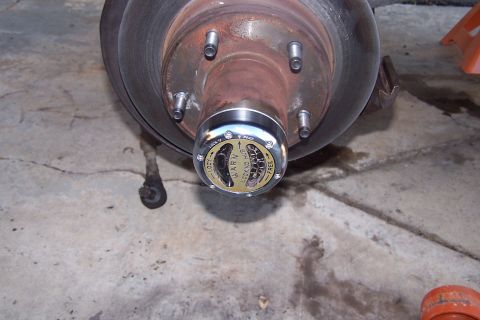 1990 Ford Bronco - Close-up of a Warn locking hub on a vehicle's wheel assembly, showing the 'LOCK' setting.
