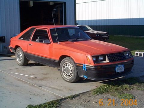 1983 Mercury Capri - This 1983 Mercury Capri is parked in front of a garage, with a second vehicle visible behind it.