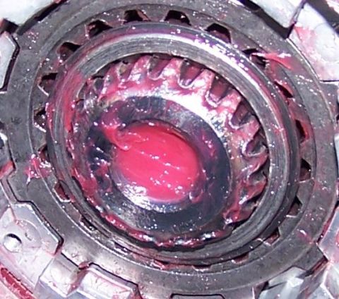 1990 Ford Bronco - Ball joint assembly covered in red grease, showing internal gears.