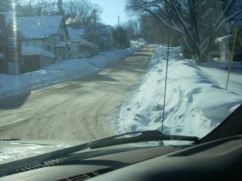 2000 Chevrolet Tahoe - Driving on a snow-covered road through a residential area on a sunny day.