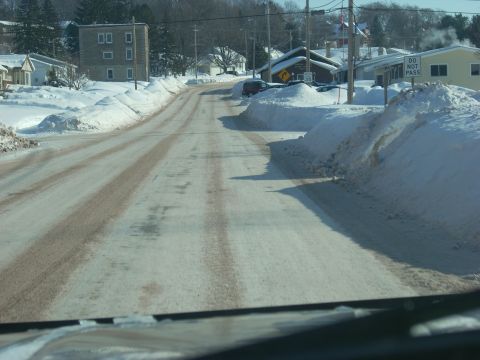2000 Chevrolet Tahoe - A road covered in snow and slush, with large snowbanks lining the sides.