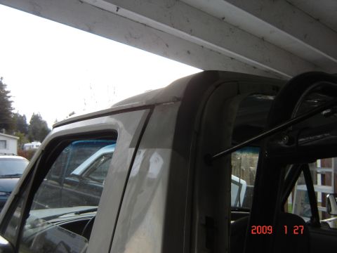1993 Ford Bronco - Close-up view of the interior roll cage and roofline of a vehicle, with another vehicle partially visible in the background.