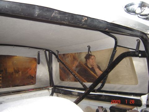 1993 Ford Bronco - The interior of a vehicle with a soft top, a person visible through a clear plastic window panel.