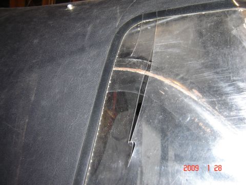 1993 Ford Bronco - The soft top window on this vehicle has a significant tear, exposing the interior and showing signs of rust.