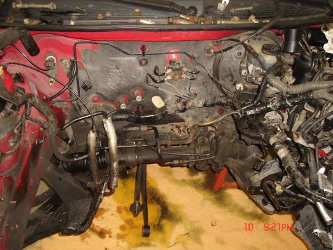 1993 Ford Probe - The engine bay is partially disassembled, revealing the steering rack and brake lines.