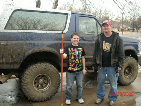 1996 Ford Bronco - A father and son pose with their muddy Ford Bronco after an off-road adventure.