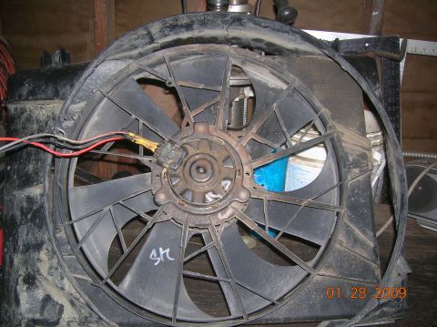 1985 Ford Bronco - A close-up view of a vehicle's radiator fan assembly, showing its motor and wiring.