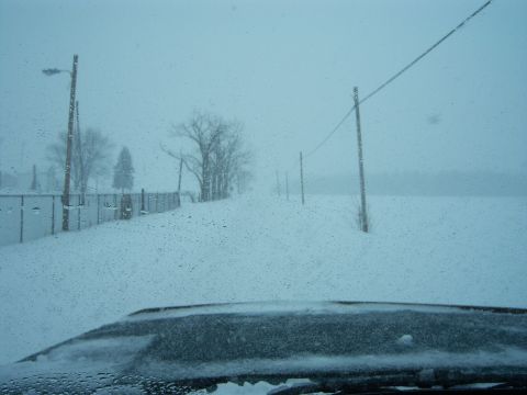 1996 Ford Bronco - View from inside a vehicle during a heavy snowstorm, with the dashboard covered in snow.