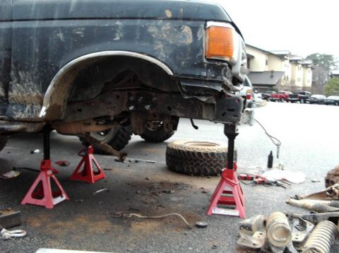 1990 Ford Bronco - This 1990 Ford Bronco is undergoing front-end repairs, with its bumper removed and the vehicle supported by jack stands.
