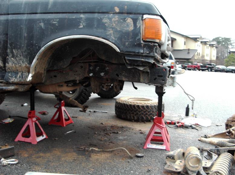 Black 1990 Ford Bronco with front bumper removed and on jack stands