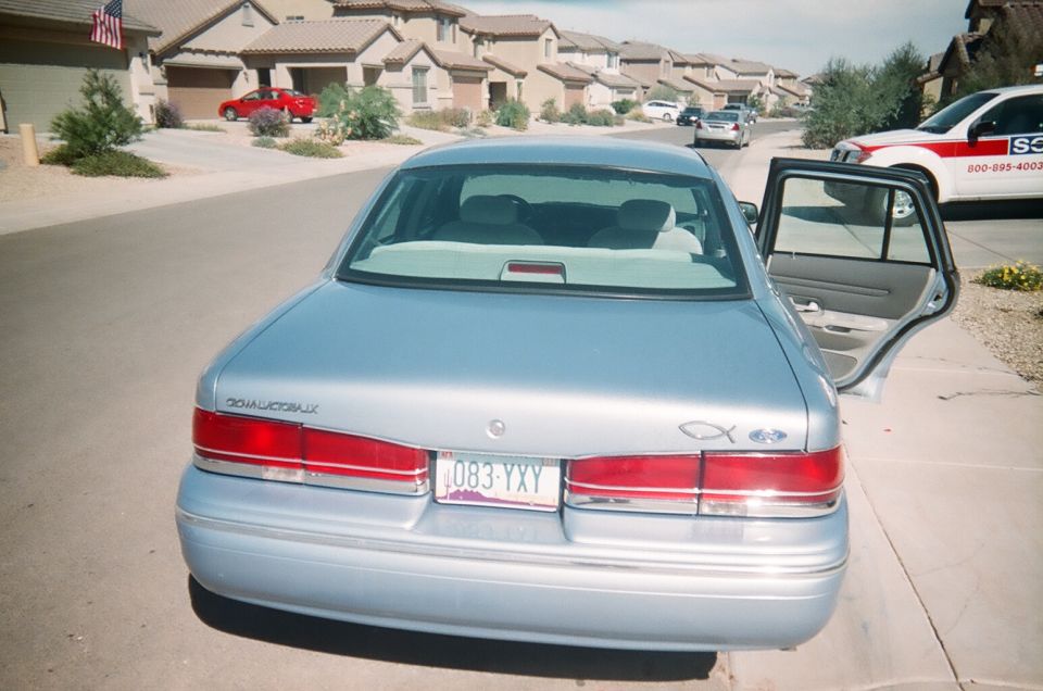 Silver Mercury sedan with rear door open in a suburban driveway