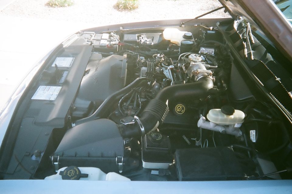 engine bay with hoses, battery, and fluid reservoirs
